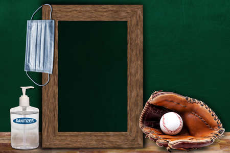 COVID-19 new normal sports concept in a classroom setting showing framed chalkboard with copy space and baseball glove and ball on wooden table.の写真素材