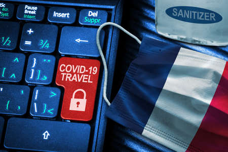 France COVID-19 coronavirus travel restrictions concept showing red button warning on keyboard with French flag face mask and hand sanitizer. New normal in global travel.の写真素材