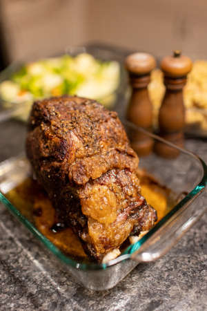 Prime rib roast beef dinner with salt and pepper shakers and dishes in the backgroundの写真素材