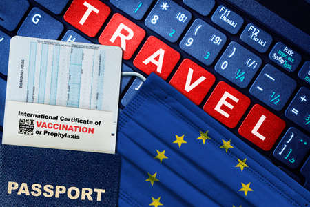 European Union new normal travel concept with passport, boarding pass, face mask with EU flag and certificate of  vaccination on keyboard. Vaccine passport concept.の写真素材