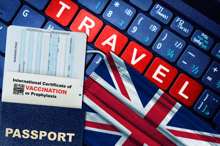UK new normal travel concept with passport, boarding pass, face mask with UK flag and certificate of  vaccination on keyboard. Vaccine passport concept.の写真素材