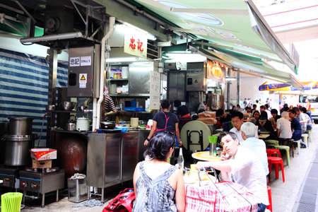 HONG KONG - APR. 19, 2011: Lunch time crowd eat at open-air street food stalls known as Dai Pai Dong in Hong Kong Central. These outdoor kitchens are now a Hong Kong heritage and culture.のeditorial素材