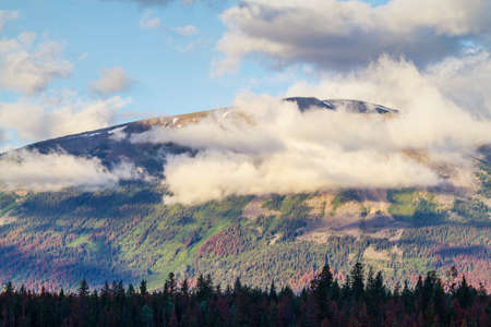 Sunrise clouds cover the majestic Rocky Mountains at Annette Lake in Jasper National Park.の写真素材