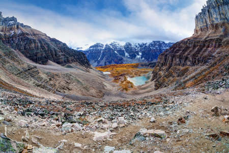 Wide angle panorama of Sentinel Pass in the Canadian Rockies at Moraine Lake with Mount Temple and Eiffel Peak, nicknamed Eiffel Tower, opening up to Larch Valley with the famous snowcapped Valley of the Ten Peaks covered by heavy clouds.の写真素材
