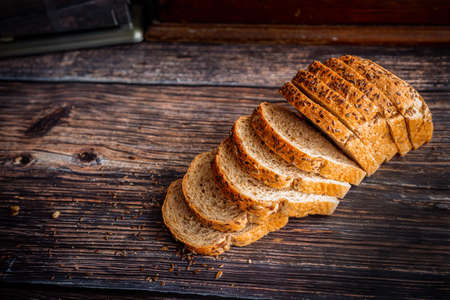 Freshly baked whole wheat flax seed bread sliced on rustic wooden table with copy space.の写真素材