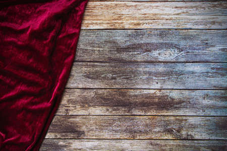 Red fabric velvet table cloth on empty wooden table background with copy space.の写真素材