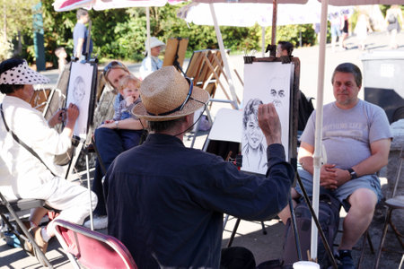 VANCOUVER, CANADA - JULY 25, 2010: A man sits for a portrait artist as he sketches in Stanley Park, Vancouver. The 1,000-acre public park is one of the most popular attractions in British Columbia, Canada, attracting approximately 8 million visitors annuaのeditorial素材