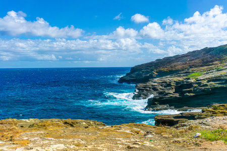 Views of the landscapes and lava tubes protruding into the ocean at Lanai Lookout on the Kalanianaole Highway in Oahu, Hawaii. It is also a popular spot for whale watching.の写真素材