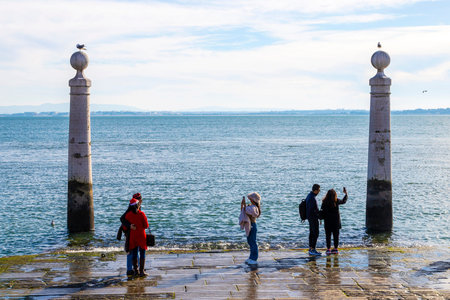 LISBON, PORTUGAL - DEC. 25, 2024: Tourists in front of famous Cais das Colunas, a historic pier in Lisbon's Praca do Comercio built in the 18th century as part of the city's reconstruction after the 1755 earthquake.のeditorial素材