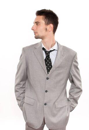 Handsome young caucasian businessman holding his hands in his pockets and looking to his rightの写真素材