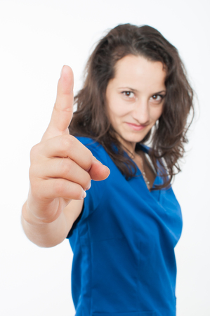 Young female doctor in blue coat pointingの写真素材
