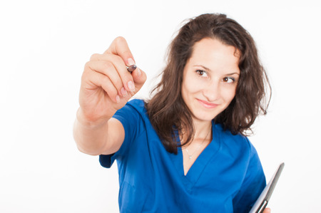 Young female doctor in blue coat writingの写真素材