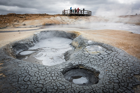 Hverir, geothermal area in Northern Iceland, with steam and mud pools. tourists enjoying the viewの写真素材
