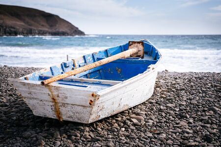 Boat on black beach in Pozo Negro, fisherman's village in Fuerteventura, Canary Islands, Spain. Atlantic oceanの写真素材