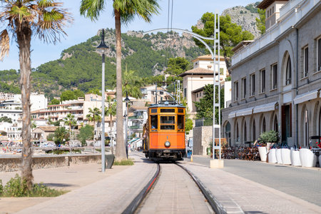 Vintage tram transports tourists through scenic Port de Soller, Majorca, Spain..