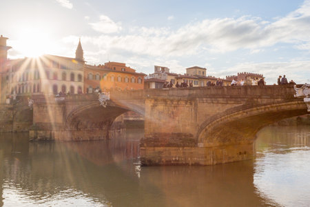 Tourists enjoy the sunset view from Ponte Santa Trinita bridge in Florence, Italy..の写真素材