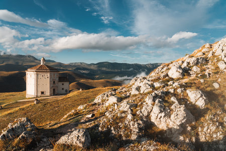 Isolated church on a mountain with village in the distance. Abruzzo, Italyの写真素材