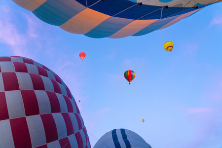 Hot air balloons ascend into the sky during a sunriseの写真素材