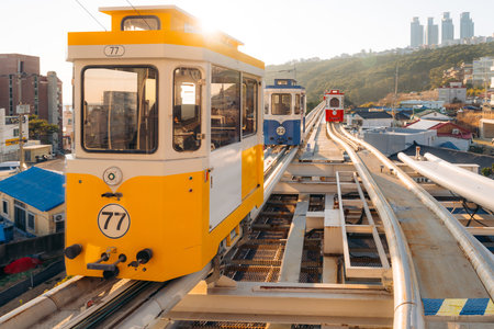 Busan monorail cars climb a hillside track, providing scenic city transport