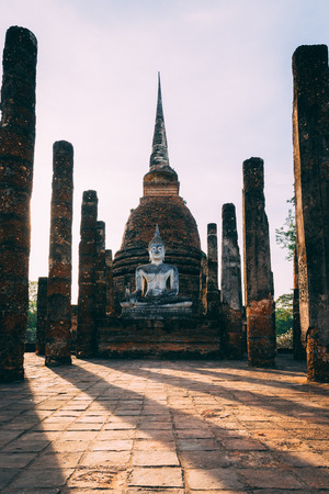 Temple complex in Sukhothai, Thailand. Beautiful historic park in the middle of Thailand. Sitting statue in front of the pagodeの写真素材