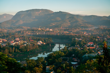 Sunset in Lunag Prabang, Laos. Beautiful clouds over the city. Mekong river between trees and houses.  Winter in Laos.の写真素材