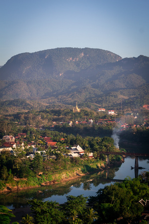 Beautiful clouds over the city. Mekong river between trees and houses.  Winter in Laos.の写真素材