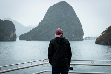 Halong Bay in mystical clouds. Mystical atmoshpere in the world famous halong bay. the limestone green rocks and the emerald green water gave a great contrast to the cloudy scene.の写真素材