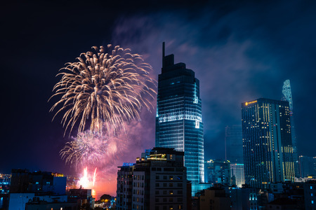 Celebration. Skyline with fireworks light up sky over business district in Ho Chi Minh City ( Saigon ), Vietnam. Beautiful night view cityscape. Holidays, celebrating New Year.のeditorial素材
