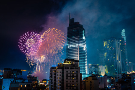 Celebration. Skyline with fireworks light up sky over business district in Ho Chi Minh City ( Saigon ), Vietnam. Beautiful night view cityscape. Holidays, celebrating New Year.のeditorial素材