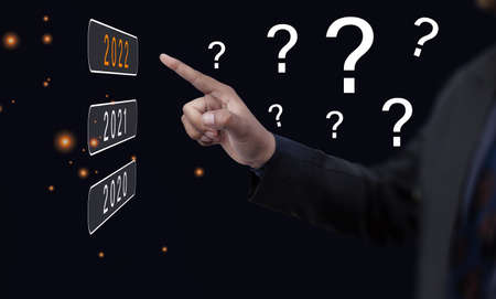 Close-up, A man holding Mobile and numbers 2022 is a startup concept driving global business in the new year.の写真素材