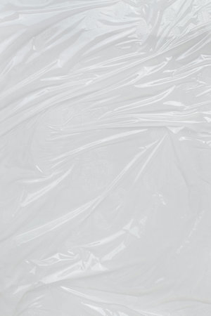 Vertical transparant wrinkled plastic, white plastic or polyethylene bag texture, macro, white backgroundの写真素材