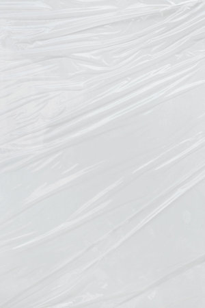 Vertical transparant wrinkled plastic, white plastic or polyethylene bag texture, macro, white backgroundの写真素材