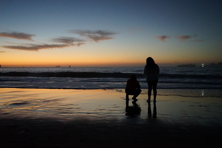 Romantic Couple on beach at sunset dusk golden hour oceanの写真素材