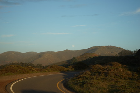 moon rise over california hills and winding roadの写真素材