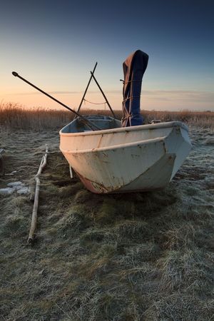 Fishing boat at sunrise on landの写真素材