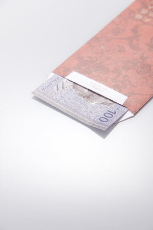 Red Ang Pao Packet with Malaysia Bank Note on right top with close up on RM100の写真素材