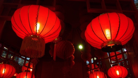 A Pair of Red Lantern Hang on Ceiling with few at the backgroundの写真素材