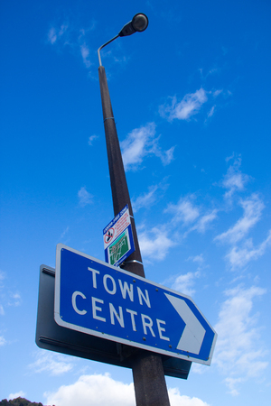 Signboard attached on street lamp with blue skyの写真素材