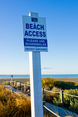 Beach access signboard at the sea side with blue skyの写真素材