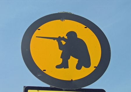 Yellow sign of a soldier in shooting position - indication of a military shooting zone areaの写真素材