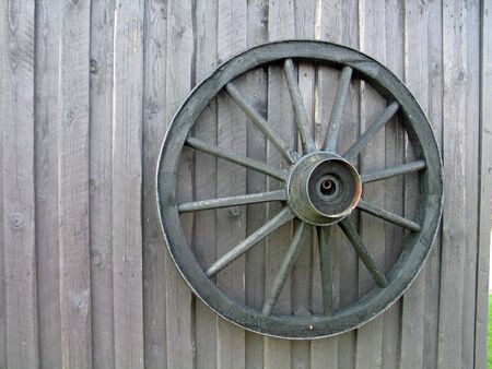 Wooden wagon wheel on an old barn doorの写真素材