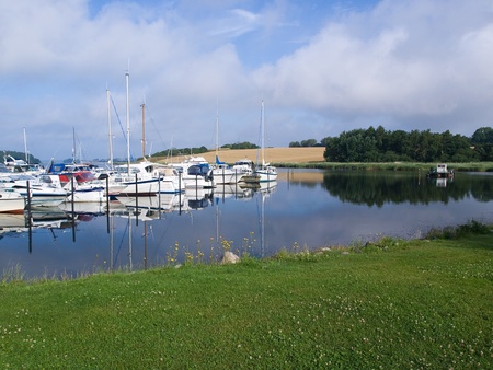 Yachts and sail boats moored to docks in a marina - sailing background image