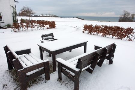 Garden furniture in winter time with snow covered landscapeの写真素材