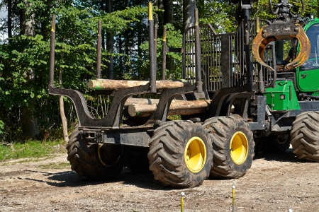 Heavy harvester loader truck doing forestry work in the forest with logsの写真素材
