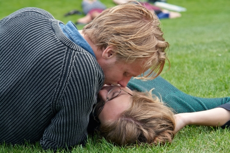 Young couple deeply in love outdoors on the grass in a park                              のeditorial素材