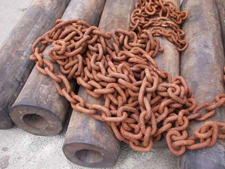 Rusty old iron chains on the ground in a portの写真素材