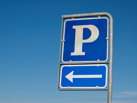 Parking symbol sign with direction arrow with clear blue sky backgroundの写真素材