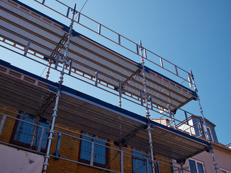 Modern sophisticated scaffolds on a house building under extensive renovationsの写真素材