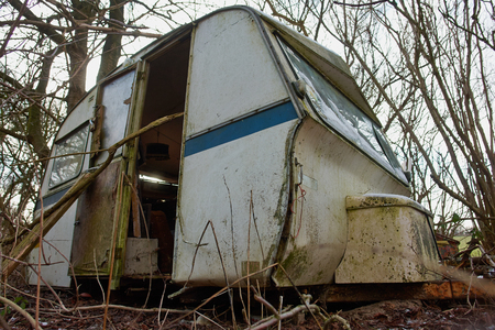 Old Vintage Dirty Abandoned Camper Camping Wagon Caravan  in a small forestの写真素材