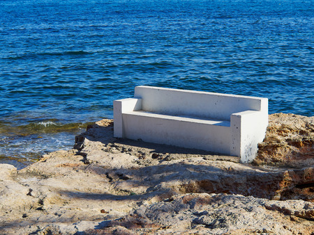 Bench made of stone in beautiful popular summer tourism destination Torrevieja beach, Costa Blanca, Valencia, Spainの写真素材